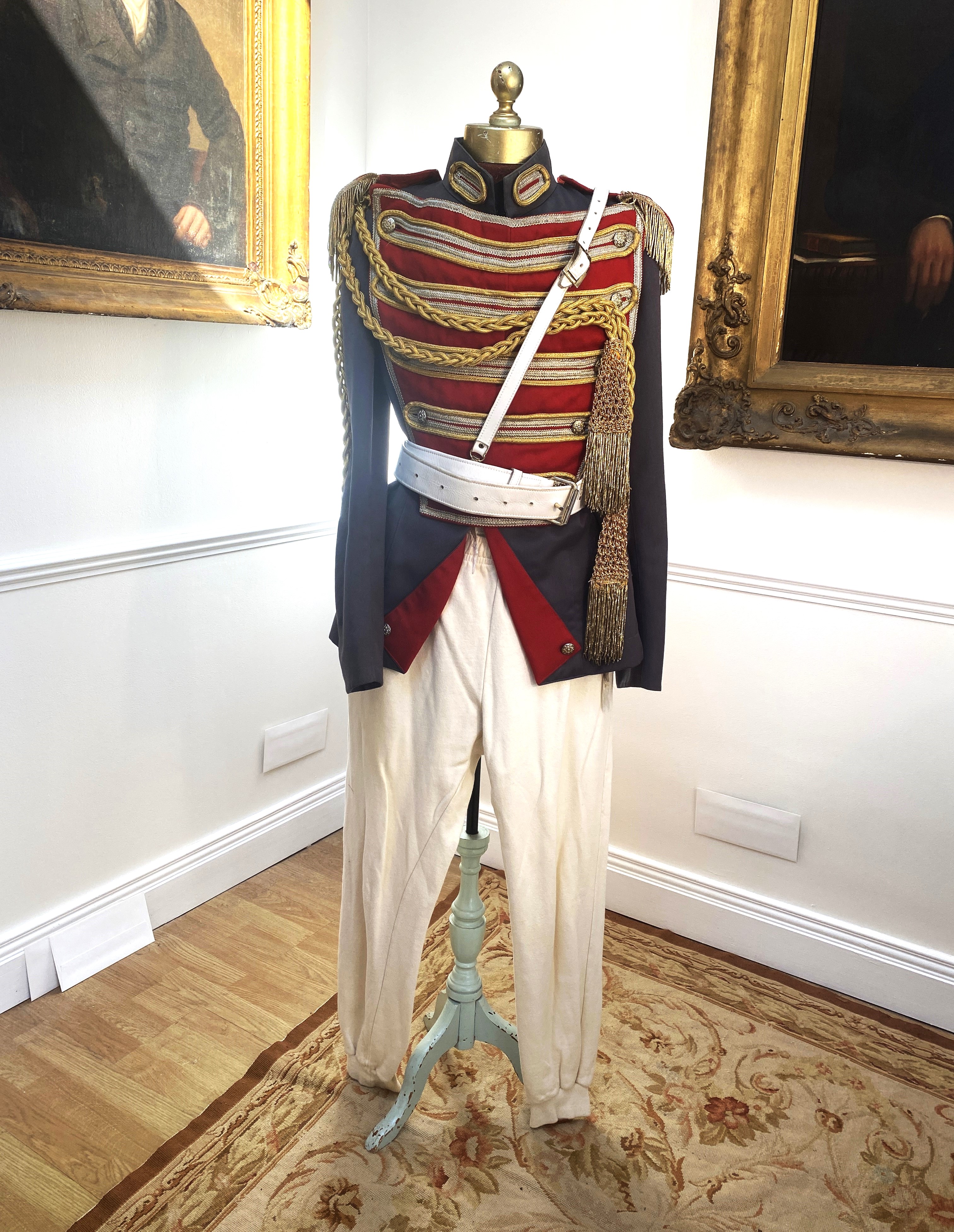 A military style uniform with elaborate trim and epilates and other accessories, cream leggings and black velvet over leggings, labelled The Netherlands Opera